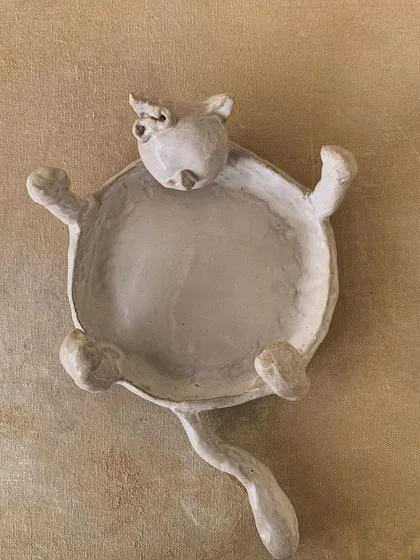 A whimsical cat-shaped dish, unglazed and full of personality.