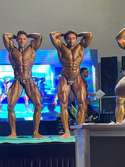 Abs and thigh pose on stage.