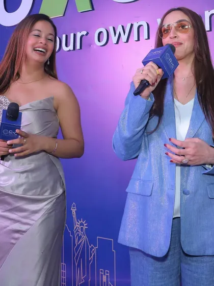 A candid moment of laughter while interacting with Esha Deol on stage.