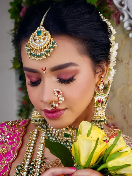 A close-up of the Maharashtrian bridal makeup look, focusing on the pink eyeshadow, defined brows, and the traditional half-moon bindi.