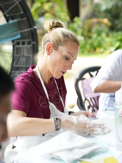 A participant at an outdoor corporate workshop focused on her project. We can set up our creative sessions in any environment, indoors or out.
