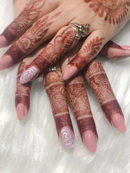 A soft and romantic look for this bride. I used a gentle pink polish for the base and added a delicate white rose design on the accent nails to match her elegant henna.