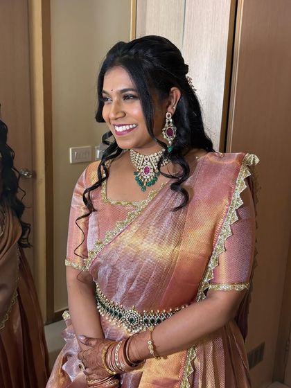 Another look at Sushmitha's reception style. The Victorian choker with emerald and ruby details adds a touch of colour and sophistication to her shimmering saree.