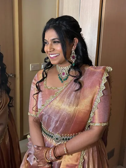 Another look at Sushmitha's reception style. The Victorian choker with emerald and ruby details adds a touch of colour and sophistication to her shimmering saree.
