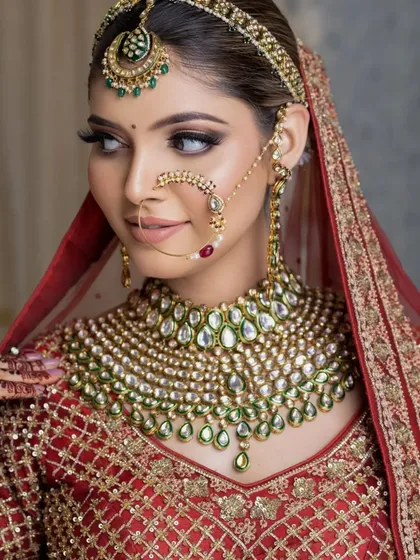 A stunning portrait of a bride looking to the side, showcasing her contoured cheekbones, defined jawline, and the beautiful craftsmanship of her necklace and nose ring.