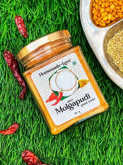 Our Molgapudi jar sitting on a bed of fresh green grass, surrounded by its core ingredients. This image represents our commitment to natural, fresh, and pure products.