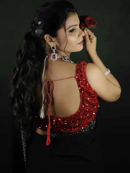 A view of the back, showing the stylish sequined blouse and the simple, elegant ponytail hairstyle that keeps the focus on the outfit.