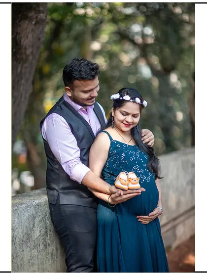 A proud couple shows off a pair of tiny baby shoes, ready to welcome their new arrival.