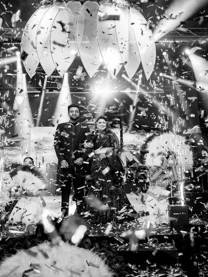 A grand stage entrance captured in a shower of confetti. This black and white shot is a testament to the 7 years we've spent making these magical, high-impact moments happen.
