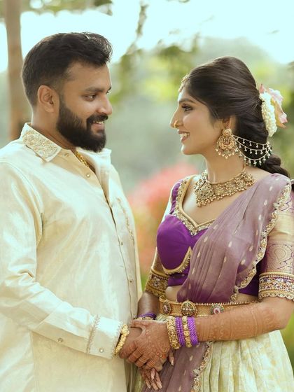 A close-up of a couple sharing a smile. The detailed embroidery on his kurta collar and her blouse showcases the fine craftsmanship we bring to every outfit.