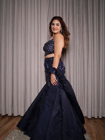 A side profile of the navy blue fishtail lehenga. This angle shows the dramatic mermaid cut of the skirt, which is excellent for creating and accentuating curves, making it a great choice for rectangle or hourglass body shapes.