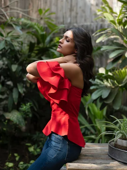 A dynamic shot of the red ruffled top from It Girl, with the model's pose conveying a sense of grace and movement.