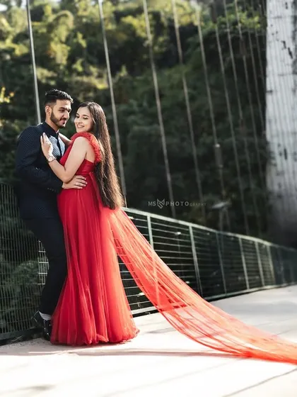 We use dramatic locations like this suspension bridge in Rishikesh to create powerful, film-like images. The long trail of the red gown flowing in the wind adds movement and a touch of grandeur to your couple portraits.