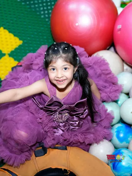 A happy girl enjoying the ball pit. It's one of the most popular spots in our play area for a reason.