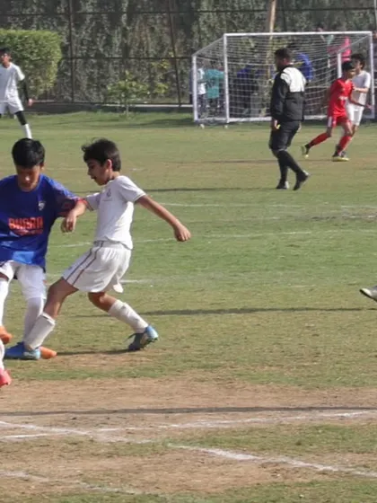 Intense midfield action during a GYL 2025 match. Our players are learning to navigate crowded spaces and work together.