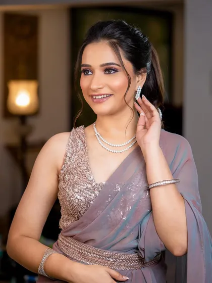 For this sangeet, we went with a glittery and glamorous look. The soft purple smokey eye and glossy lip are paired with a voluminous, wavy ponytail.