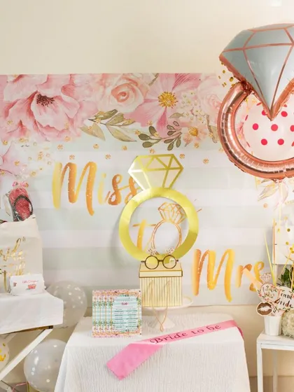 I can help you set the scene for a perfect bridal shower or bachelorette party. This "Miss to Mrs" setup includes a floral backdrop, themed balloons, a "Bride to Be" sash, and fun photo props to create a memorable celebration.