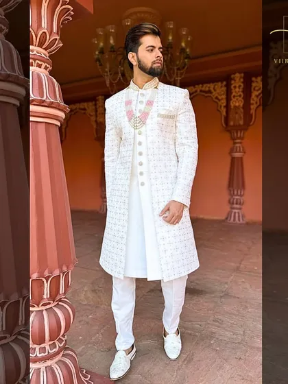 The full look of our white embroidered sherwani. Paired with white trousers and shoes, it creates a stunning, cohesive outfit for a day wedding.