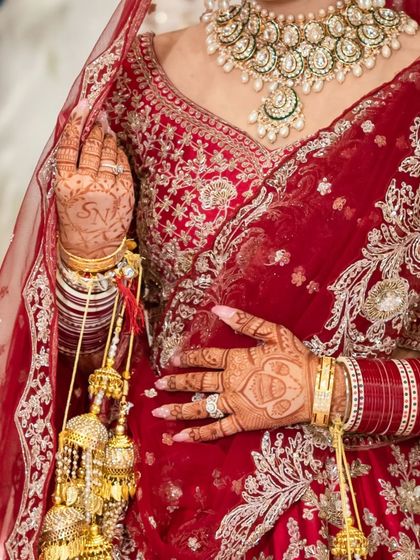 A detailed shot of the bride's hands, showcasing the intricate mehendi, the traditional chooda, and the stunning kalire.