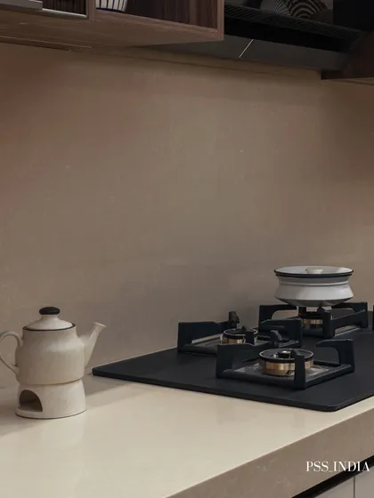 Simplicity at its best. A minimalist teapot and a single pot on the stove are all that's needed to add a touch of warmth and personality to this clean and modern cooktop area.