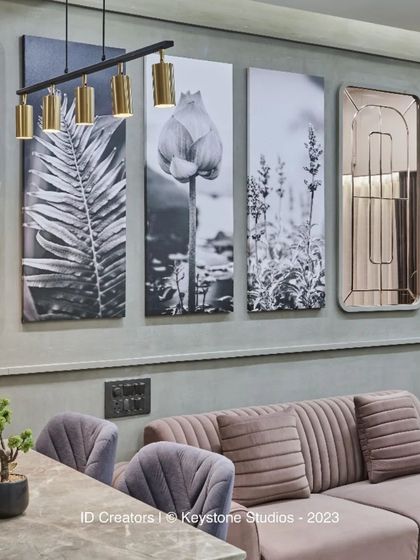 A close-up of the wall decor, which includes rose-tinted mirrors and black-and-white floral photography, creating an elegant and modern composition.
