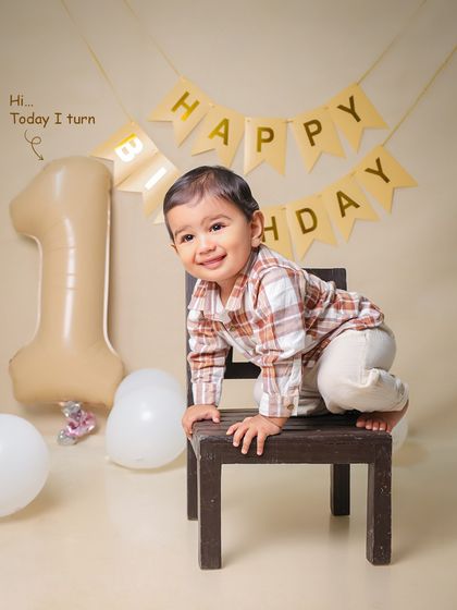 "Today I turn 1." This little one is ready to climb and explore during his birthday photoshoot, showing off his curious and playful nature.