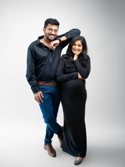 A modern and stylish portrait that showcases their personalities. The clean white background and simple outfits keep the focus on their happy, relaxed interaction. It’s a snapshot of their life right now.