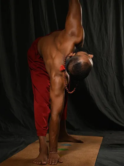 A high-angle view of Utthita Trikonasana (Triangle Pose). This foundational standing pose lengthens the side body, opens the hips and shoulders, and improves overall stability, both mental and physical.
