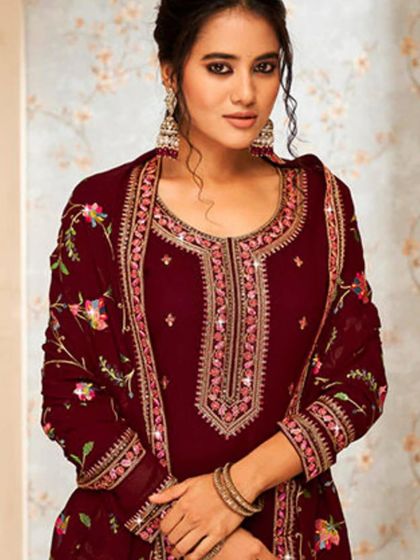 A rich brown salwar kameez with delicate floral embroidery. The georgette fabric and mirror work add a touch of elegance and shine.