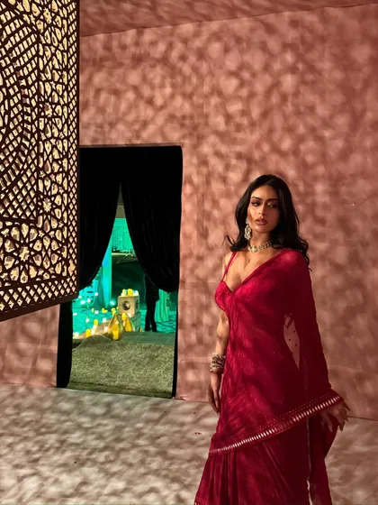A closer view of Nysa in the red saree, highlighting the delicate fabric and the statement necklace.