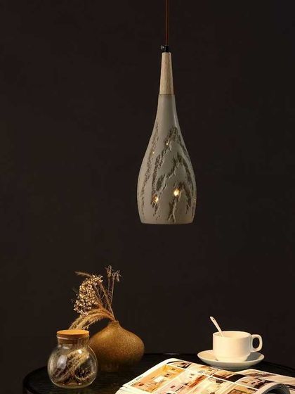 A single teardrop-shaped pendant with a unique, textured ceramic finish. This fixture is perfect for adding an artisanal touch over a small table.