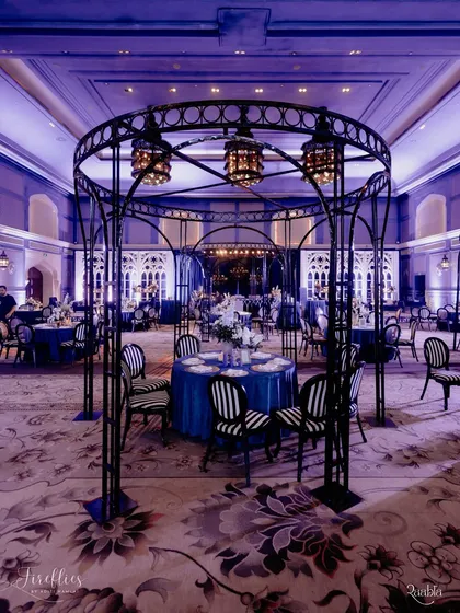 A striking seating arrangement at the 'Gothic Palace Ball', featuring a wrought-iron gazebo-like structure and bold, black-and-white striped chairs. This was a central feature of our dramatic Sangeet design.
