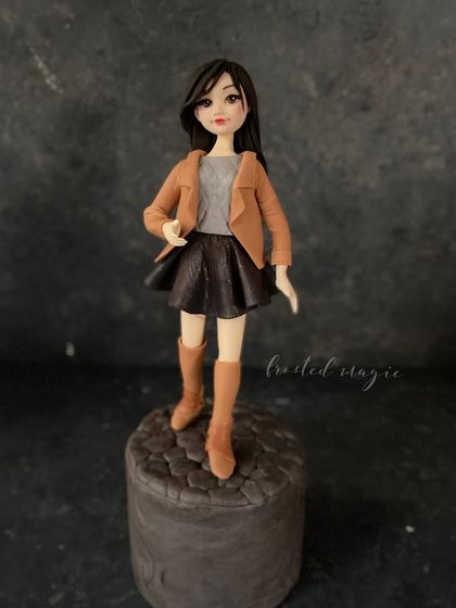 The same figurine against a darker background, which makes the details of her jacket and hair pop.