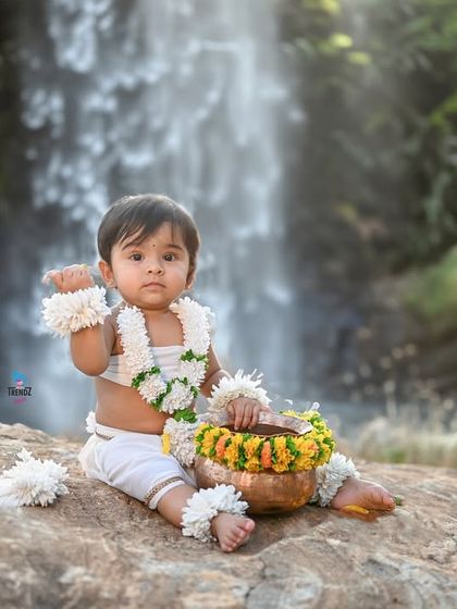 An artistic edit of an outdoor photo, placing the baby against a beautiful waterfall background.
