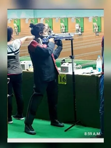 A student competing at the UP State Shooting Championship, showing excellent form with her air rifle.