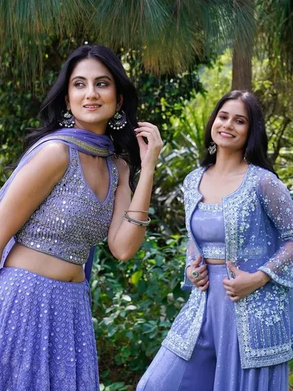 A candid shot of two models in lavender ethnic wear, set against a natural, green backdrop. Their relaxed poses and smiles give the image an authentic feel, perfect for a lifestyle-oriented fashion brand.