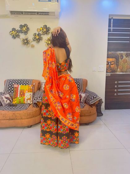 A back view of the black and orange Garba lehenga, showing the backless blouse design.