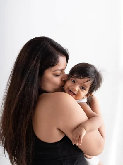 A mother's love captured in a simple, beautiful moment. The baby's happy giggle makes this an incredibly precious photograph.
