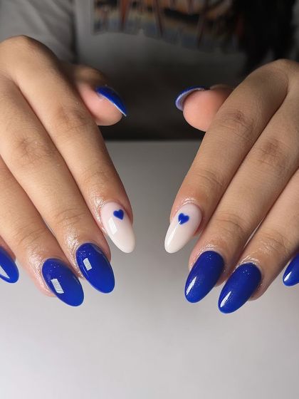 Blue skies, happy vibes, and hearts on nails. This design features a bold cobalt blue with accent nails in white, each with a tiny blue heart.