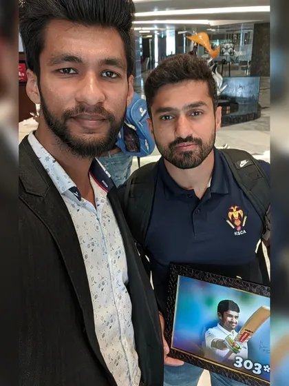 A photo with cricketer Karun Nair, holding a colored artwork I made for him celebrating his triple century.