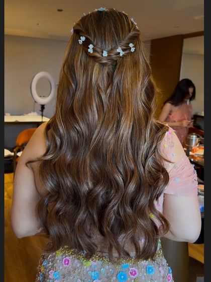 A close-up of the wavy hairstyle, showing the texture and the pretty floral braid detail.