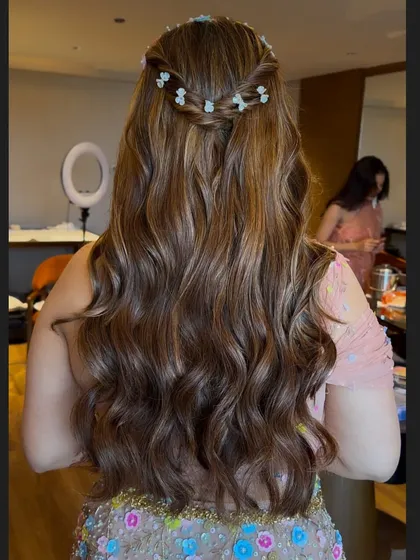 A close-up of the wavy hairstyle, showing the texture and the pretty floral braid detail.