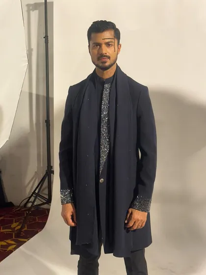 A final look before walking the ramp, ensuring every element of the outfit is perfectly in place.