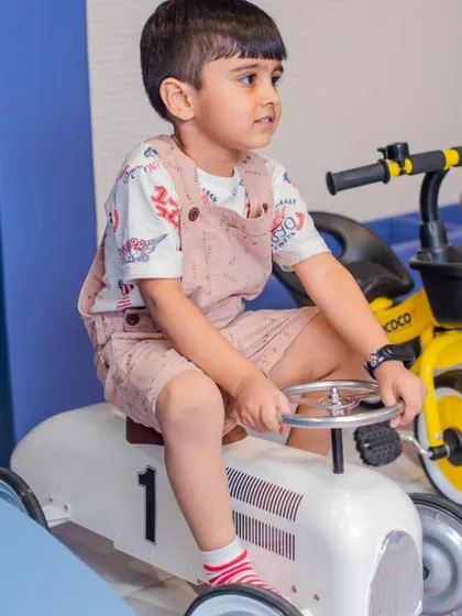 A young boy enjoying a ride on one of our classic toy cars. We have a variety of vehicles for little drivers to choose from.