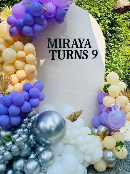 A detailed shot of the purple, peach, and silver balloon arrangement.