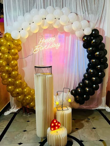A classic black, white, and gold balloon ring decoration. This timeless color combination is perfect for milestone birthdays and elegant parties.
