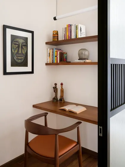 This study pod features a custom-designed floating desk and a curved wooden armchair with a leather seat. The chair is crafted for comfort during long periods of work, without sacrificing elegance.