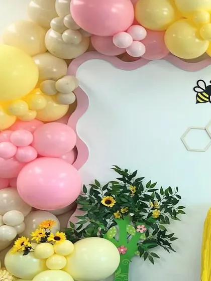 A detail shot of the balloon arch, showing the soft color palette and flower-shaped balloon clusters.