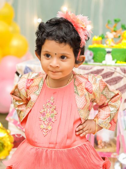 A close-up shot of the birthday girl with a curious and playful expression.