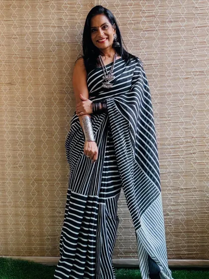 A classic black and white striped cotton Mulmul saree. This is a versatile piece that can be styled for both casual and semi-formal occasions.